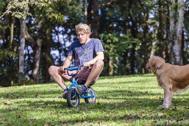 Mann fährt Kinderfahrrad, Bedugul, Bali, Indonesien - AURF07131