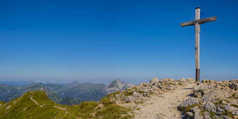 Österreich, Gipfelkreuz der Walser Hammerspitze mit Blick auf die Allgäuer Alpen in Bayern, Deutschland, lizenzfreies Stockfoto