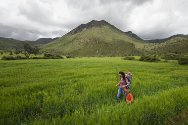 Mutter mit Sohn beim Wandern durch ein Feld im archäologischen Gebiet von Xihuingo, Tepeapulco, Hidalgo, Mexiko - AURF07162