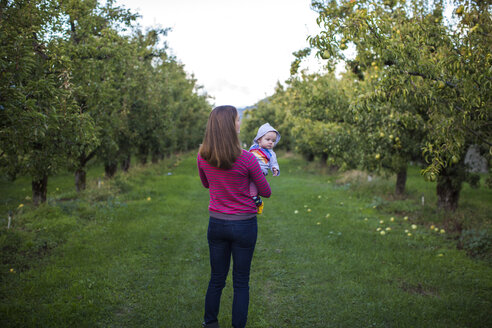 Mutter mit Baby stehend im Obstgarten, Parkdale, Oregon, USA - AURF07164