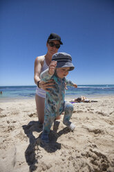 Mother helping baby boy to walk at beach, Perth, Western Australia, Australia - AURF07184