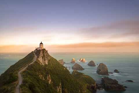 Neuseeland, Südinsel, Otago, Nugget Point Lighthouse bei Sonnenuntergang, lizenzfreies Stockfoto