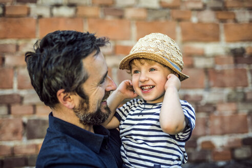Porträt eines glücklichen Kleinkindes in den Armen seines Vaters - HAPF02721