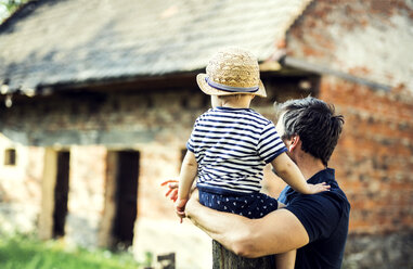 Back view of father and little son watching something outdoors - HAPF02732