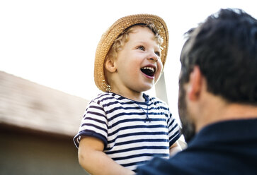 Portrait of laughing toddler on his father's arms - HAPF02733