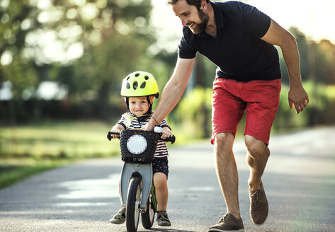 Father teaching little son riding bicycle - HAPF02736