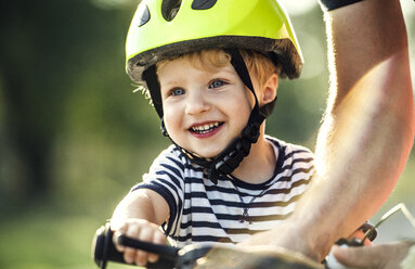 Porträt eines lächelnden Kleinkindes mit Fahrradhelm - HAPF02737