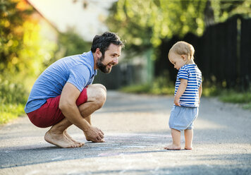 Father playing with his little daughter on the street in summer - HAPF02768