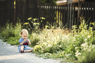 Barefoot baby girl sitting wayside watching something - HAPF02772