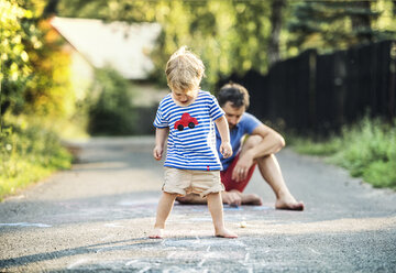 Todler playing hopscotch with naked feet - HAPF02773