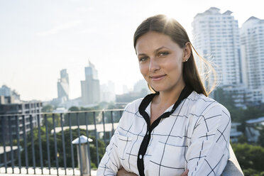 Portrait of brunette business woman on rooftop - SBOF01530