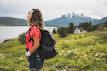 Junge Frau mit Rucksack auf Reisen im norwegischen Lappland - KKAF02043