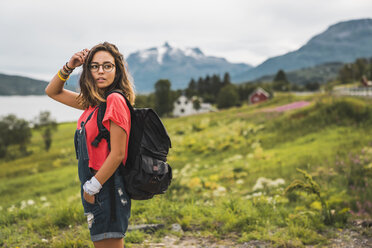 Junge Frau mit Rucksack auf Reisen im norwegischen Lappland - KKAF02044