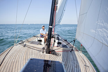 Blick vom Bug eines Mannes, der eine kleine Segelyacht steuert, in der Bucht von Arcachon, Frankreich. - AURF07266