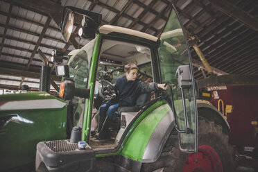 Jugendlicher bedient Traktor auf einem Bauernhof, Chilliwack, British Columbia, Kanada - AURF07313