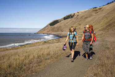 Zwei Rucksacktouristinnen wandern am Strand entlang und unterhalten sich, Lost Coast Trail, Kings Range National Conservation Area, Kalifornien, USA - AURF07328