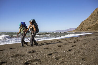 Zwei Wanderinnen wandern Seite an Seite am Strand der Lost Coast, Kalifornien, USA - AURF07329