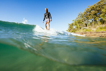 Surfer reitet auf einer Welle im Meer - AURF07335