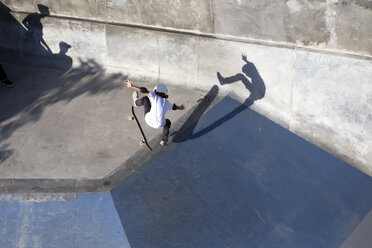 Jugendlicher macht Kickflip beim Skateboardfahren im Skatepark, Canggu, Bali, Indonesien - AURF07357