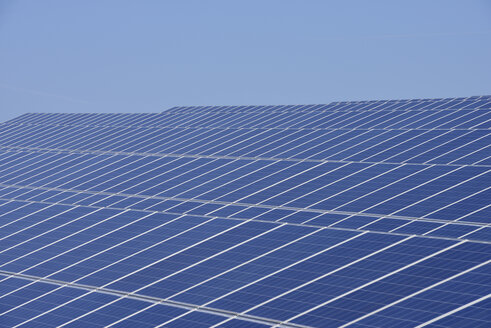 Deutschland, Blick auf eine große Anzahl von Solarmodulen auf dem Feld einer Solaranlage - RUEF01965