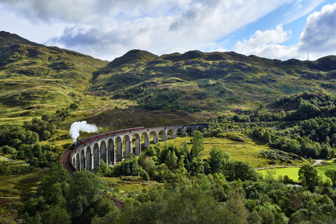 UK, Scotland, Highlands, Glenfinnan viaduct with a steam train passing over it stock photo