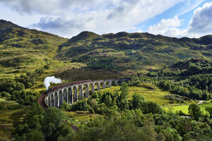 UK, Schottland, Highlands, Glenfinnan-Viadukt mit einem darüber fahrenden Dampfzug - RUEF01997