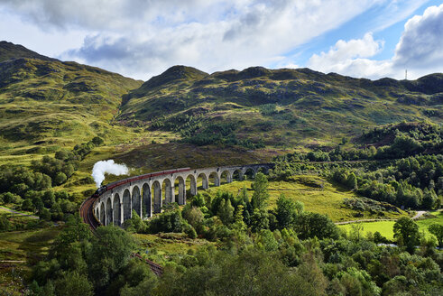 UK, Schottland, Highlands, Glenfinnan-Viadukt mit einem darüber fahrenden Dampfzug - RUEF01997