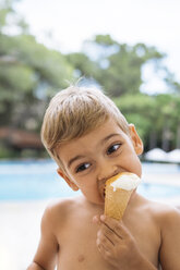 Cute toddler eating ice cream by the pool - MOMF00508