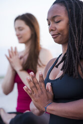 Zwei Frauen meditieren mit verschränkten Händen (Anjali Mudra), Newport, Rhode Island, USA - AURF07377