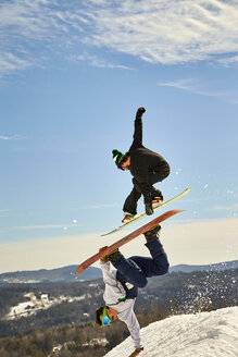 Snowboarder, der über einen anderen springt und einen Handplant-Trick macht, Vermont, USA - AURF07442