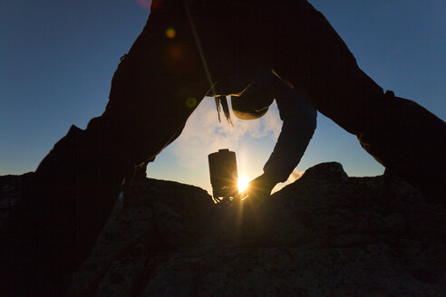 Silhouette eines Bergsteigers, der einen Campingkocher benutzt, um Wasser zu kochen, Chilliwack, British Columbia, Kanada - AURF07462