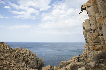 Side view of person climbing on rock in Sardinia, Sardinia, Italy - AURF07484