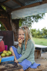 Smiling girl eating apple, Nusa Penida, Bali, Indonesia - AURF07497