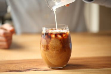 Pouring milk to glass with coffee, Oakland, USA - AURF07519