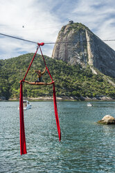 Frau macht Luftakrobatik an einem Hochseil neben dem Zuckerhut in Rio de Janeiro, Brasilien - AURF07577