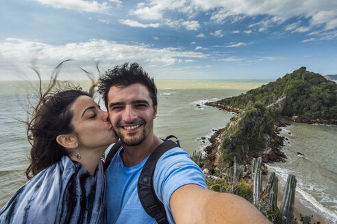 Frau küsst Mann auf die Wange, während sie ein Selfie in Buzios, Rio de Janeiro, Brasilien macht - AURF07579