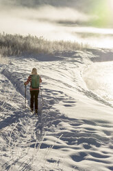 Woman cross country skiing on frosty morning along the Animas River, Durango, Colorado, USA - AURF07589