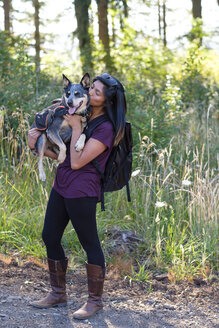 Frau hält ihren Hund während einer Wanderung in Oregon, USA, hoch - AURF07599