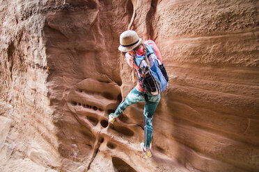 Woman climbing sandstone cliff, Grand Staircase-Escalante National Monument, Utah, USA - AURF07604