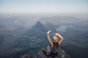 Schweiz, Grosse Mythen, junge Frau auf Wanderschaft, sitzend auf einem Felsen bei Sonnenaufgang - LHPF00046