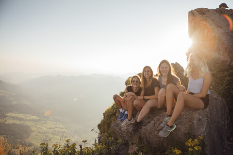 Switzerland, Grosser Mythen, four happy girlfriends on a hiking trip having a break at sunrise stock photo