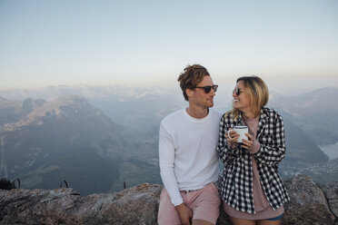 Schweiz, Grosse Mythen, glückliches junges Paar auf einer Wandertour mit Pause bei Sonnenaufgang - LHPF00062