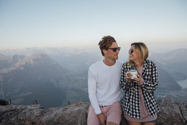 Switzerland, Grosser Mythen, happy young couple on a hiking trip having a break at sunrise - LHPF00062