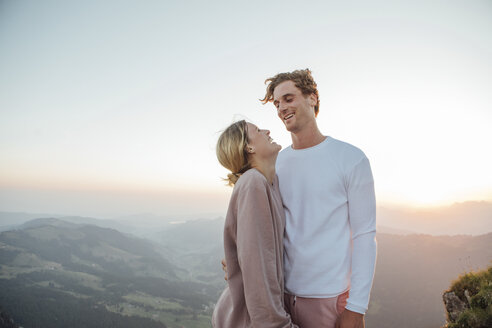 Schweiz, Grosser Mythen, glückliches junges Paar in Berglandschaft bei Sonnenaufgang stehend - LHPF00076