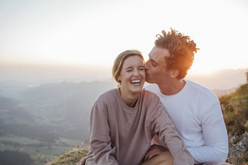 Schweiz, Grosse Mythen, glückliches junges Paar auf einer Wandertour mit Pause bei Sonnenaufgang - LHPF00081