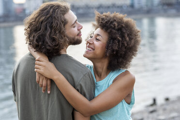 Happy young couple hugging at the riverside - FMKF05244