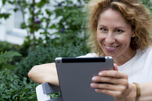Porträt einer lächelnden Frau mit digitalem Tablet - HHLMF00494