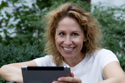 Porträt einer lächelnden Frau mit digitalem Tablet - HHLMF00495
