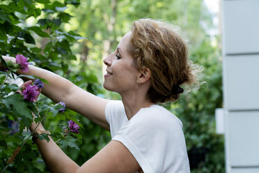 Profile of smiling woman gardening - HHLMF00497