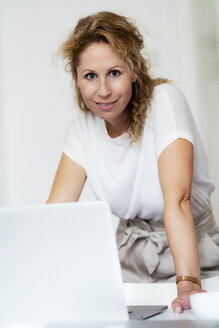Porträt einer lächelnden Frau mit Laptop - HHLMF00507